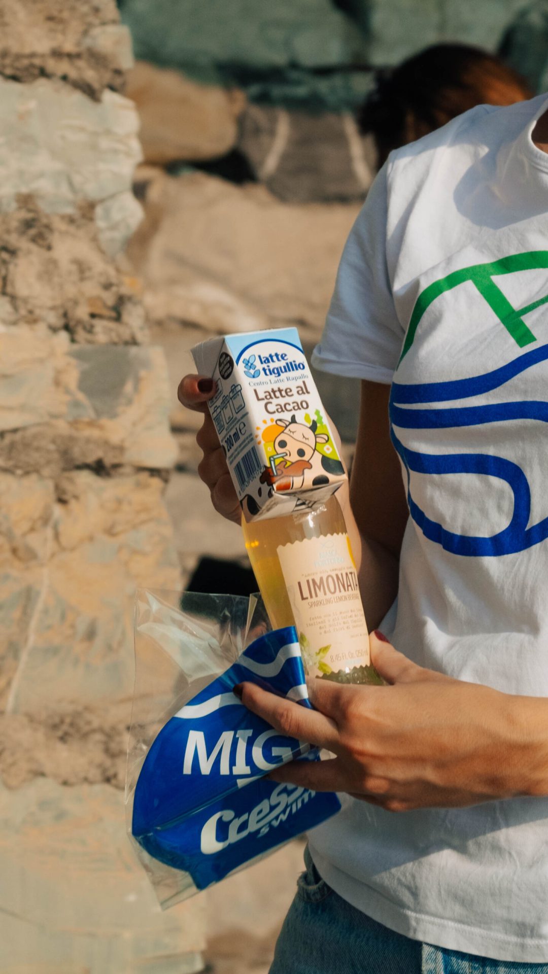 Una creatrice di contenuti a Genova cattura il suo video con una bottiglia di latte e una maglietta.